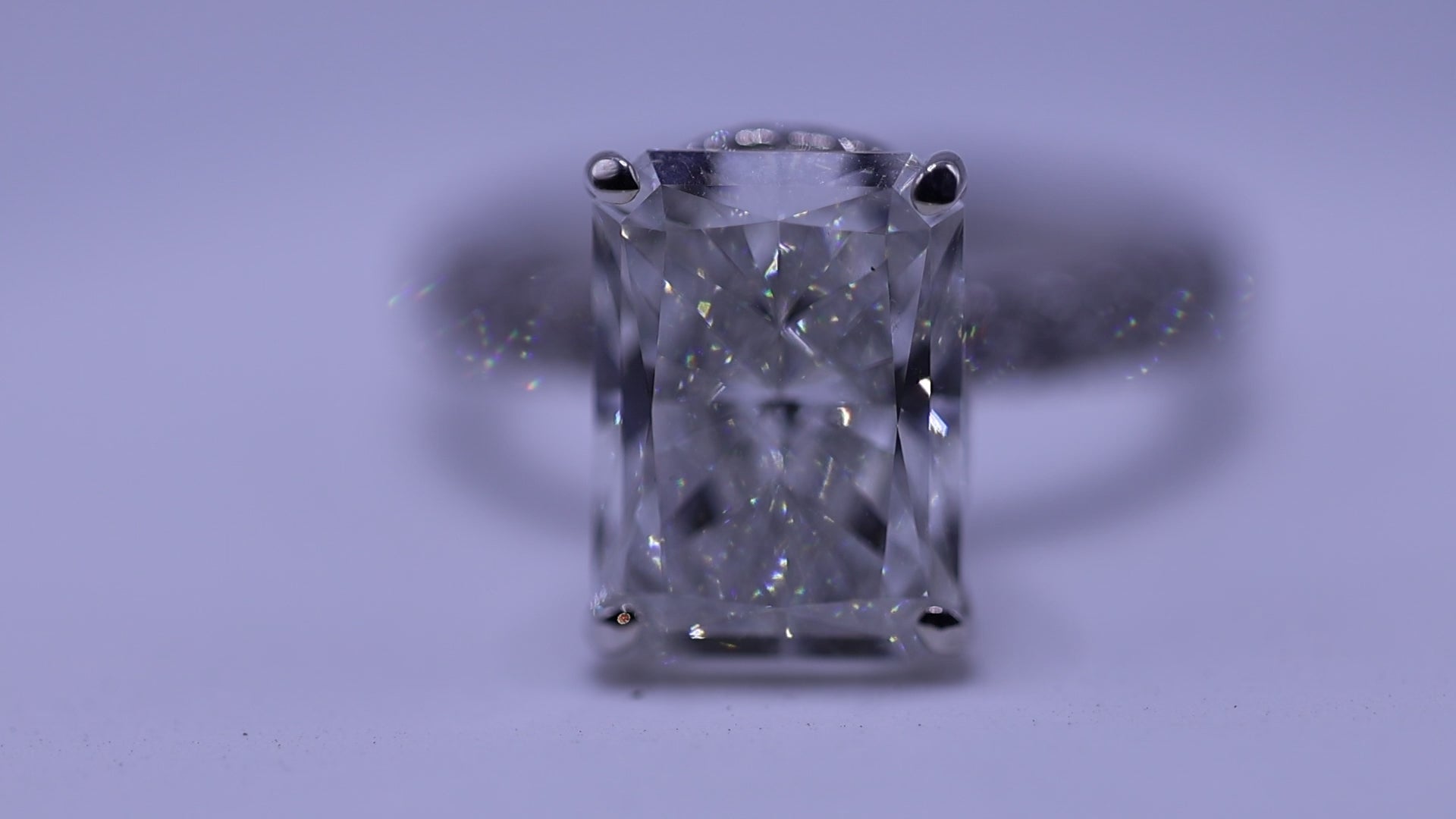 Emerald-cut diamond engagement ring close-up, white gold prong setting — ELUL by Elizabeth